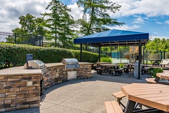 a picnic area with picnic tables and a blue roofed pavilion with a playground at Indian Creek Apartments*, Ohio, 45236